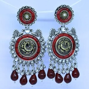 Traditional oxidised silver earrings with red enamel, peacock design, and dangling red beads by Sarvratna Jewellery